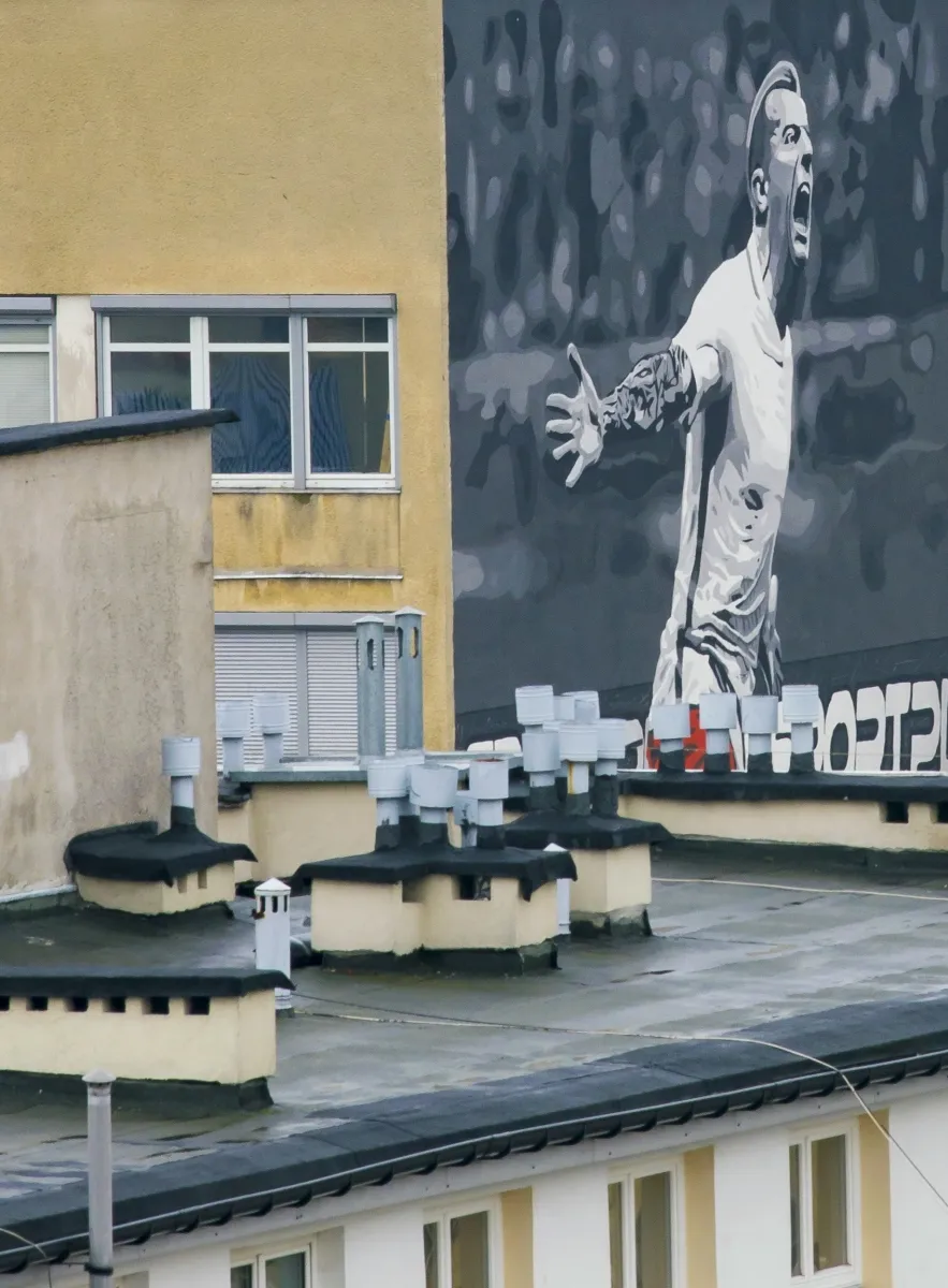 Large mural of a figure painted across a building facade